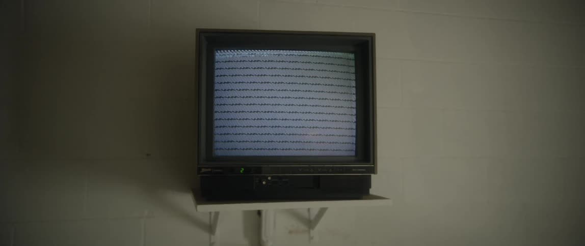 A television with no signal is on a shelf