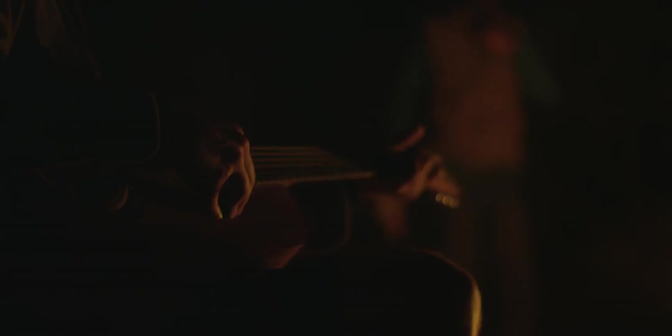 Person plucking the strings on a guitar