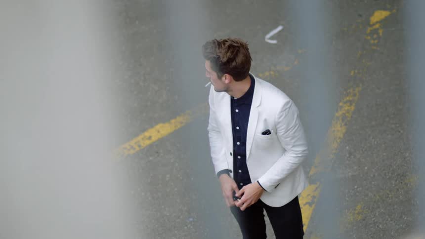 A man is smoking outdoors in the daytime