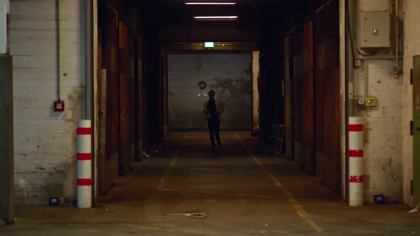A man runs through a corridor in an old building