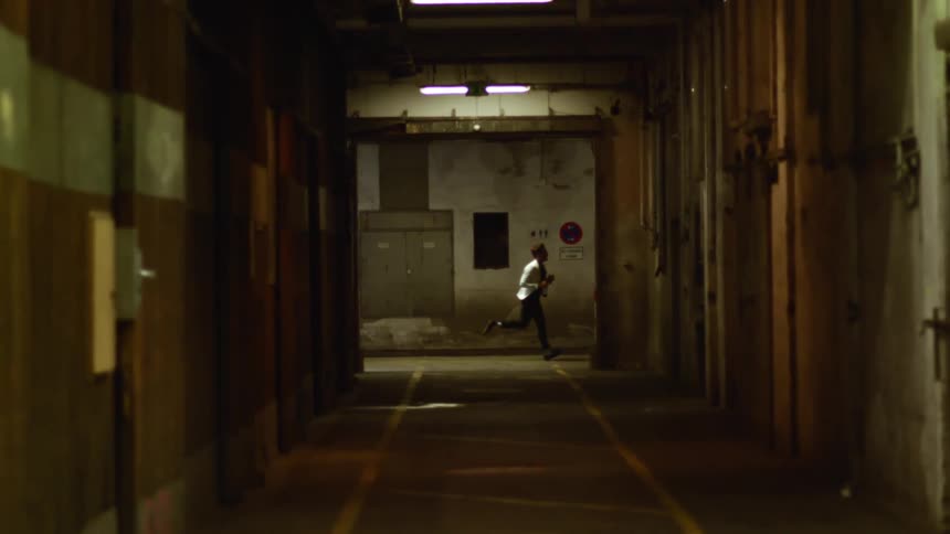 A young man runs down a street at night