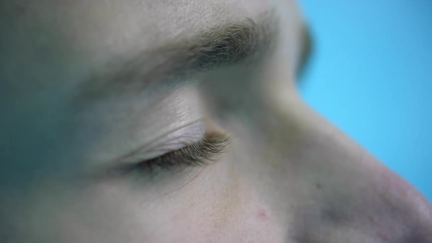 A man opens his eyes and smiles as he looks upwards