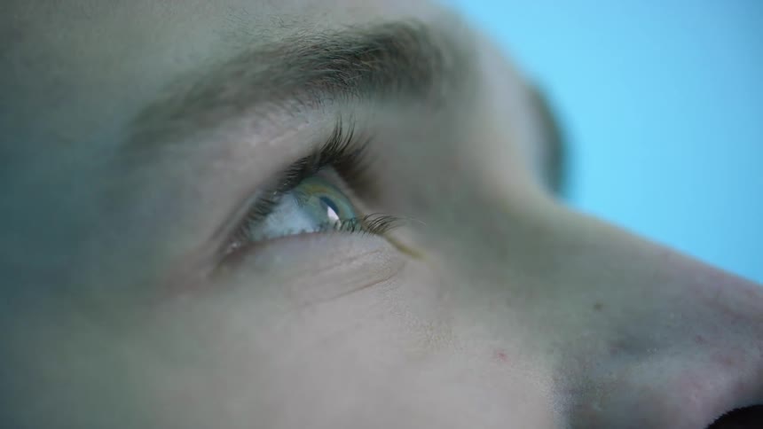 A person blinking and looking around