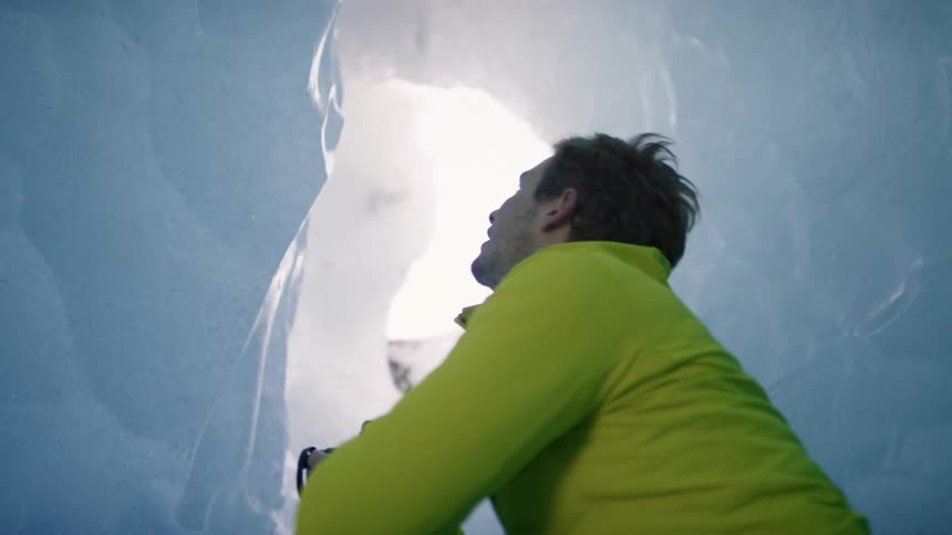 A photographer smiles as he crouched down inside an igloo