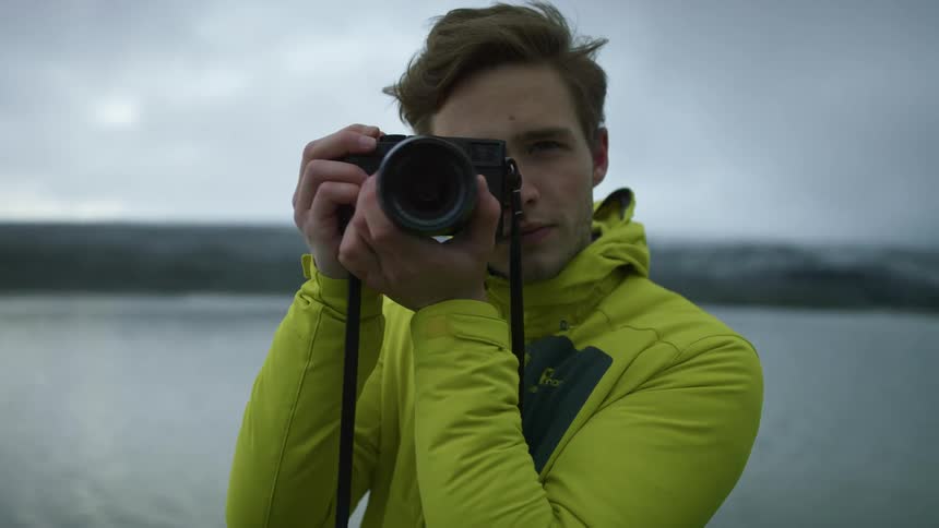 A man is taking pictures with a camera outdoors
