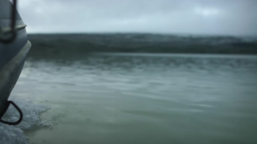 A boat floating on a lake on a cloudy winter day