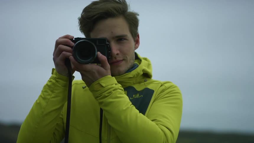 A man is standing outdoors with a camera