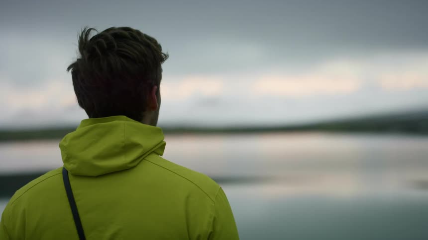 A man is standing outdoors and looking at the horizon