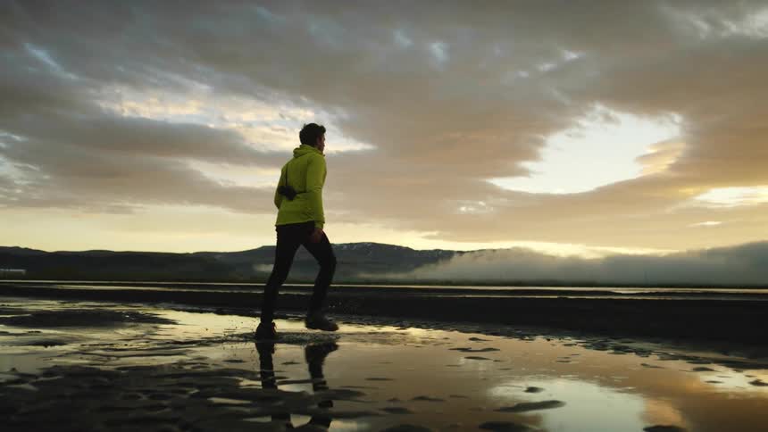 A man walks on the beach on a cloudy day