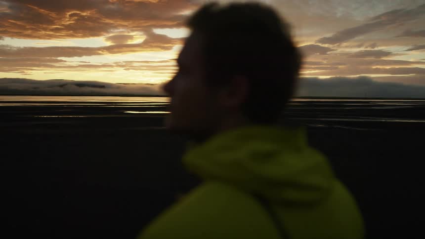 A man is standing outdoors at dusk