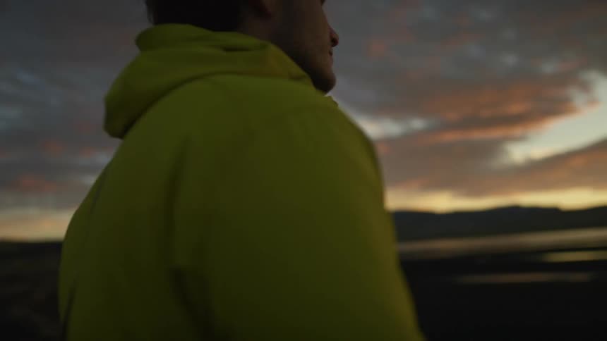 A man is hiking outdoors at dusk