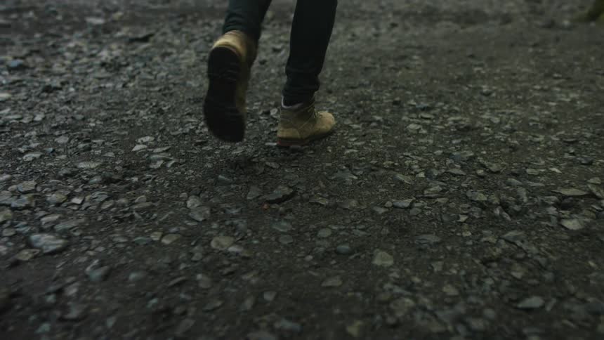 A man walks towards steam rising from the ground outside