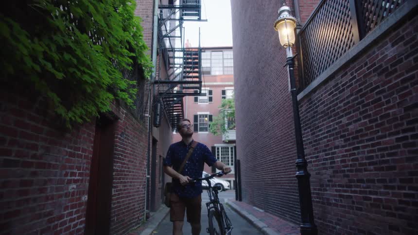 A man pushes his bike down the alley