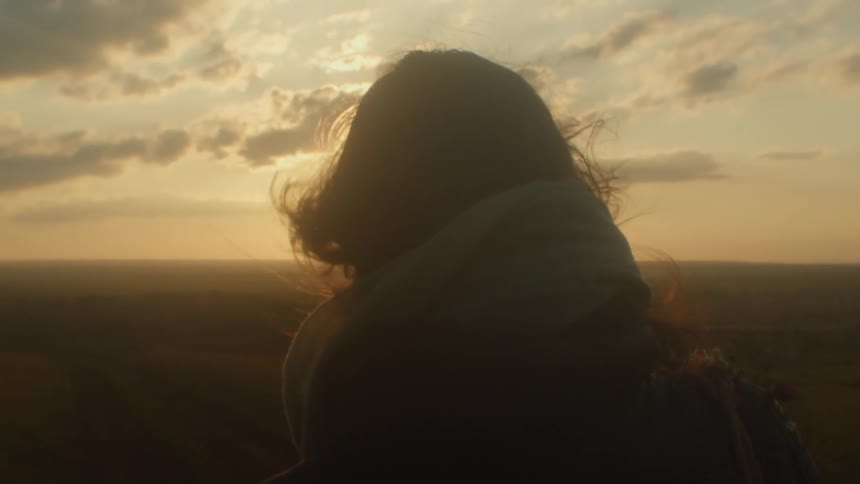 A woman is walking outdoors at dusk