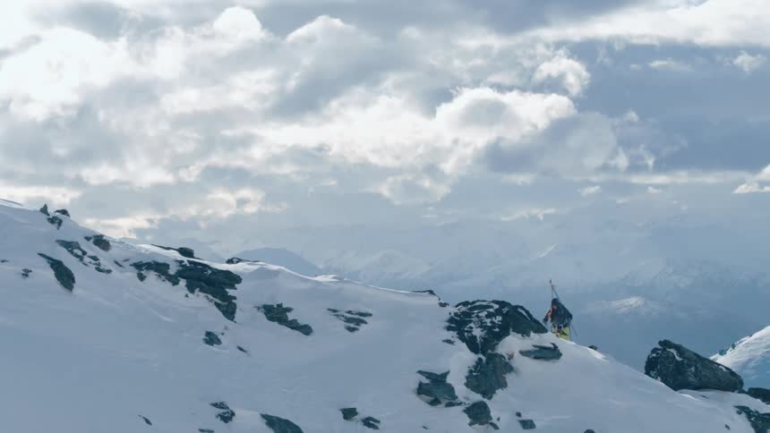 A person is a hiking up a mountain in winter