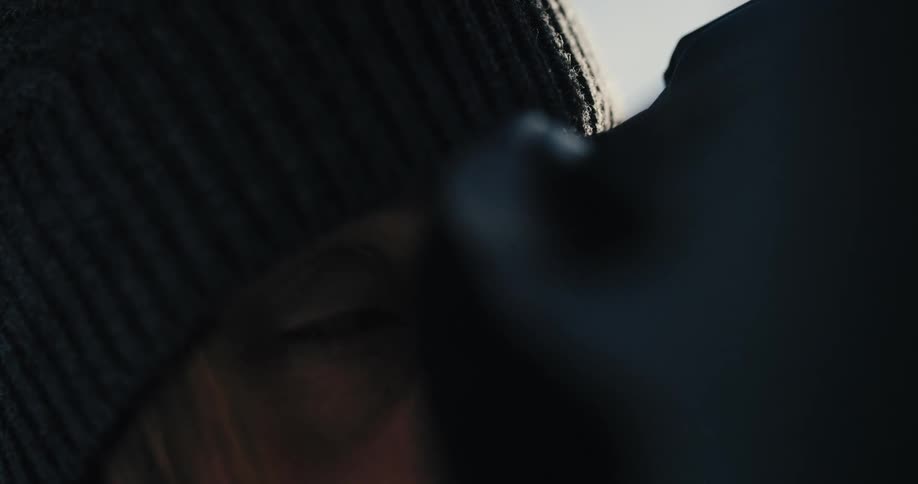A woman looks through a binoculars and smiles