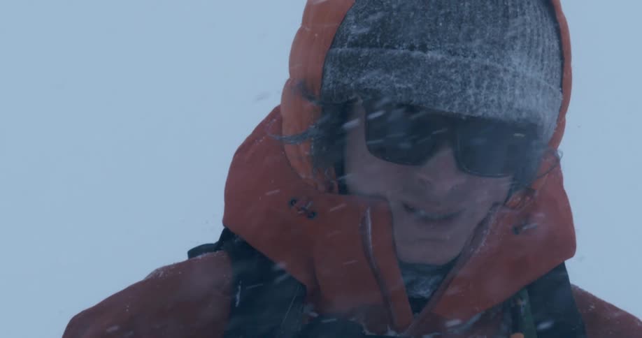 A man is walking outside during a snow storm