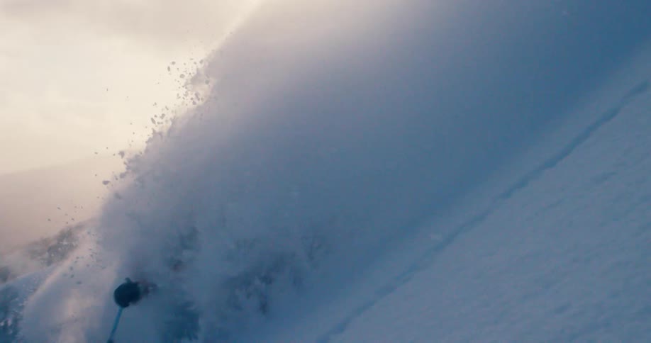 A man is skiing down a mountain in winter