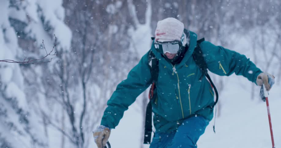 A man is skiing outdoors while its snowing