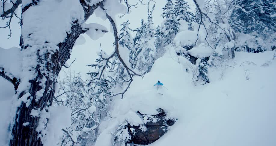 A man is skiing down a mountain in winter