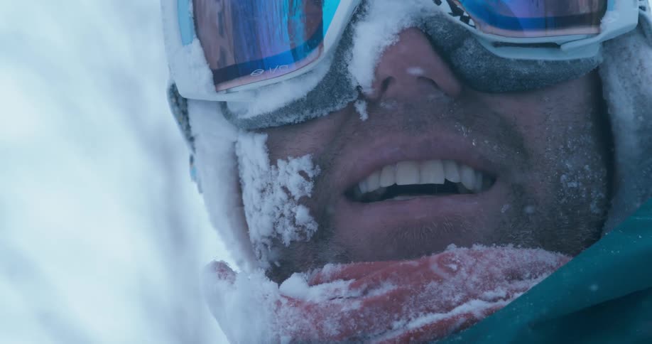 A man is smiling as it snows