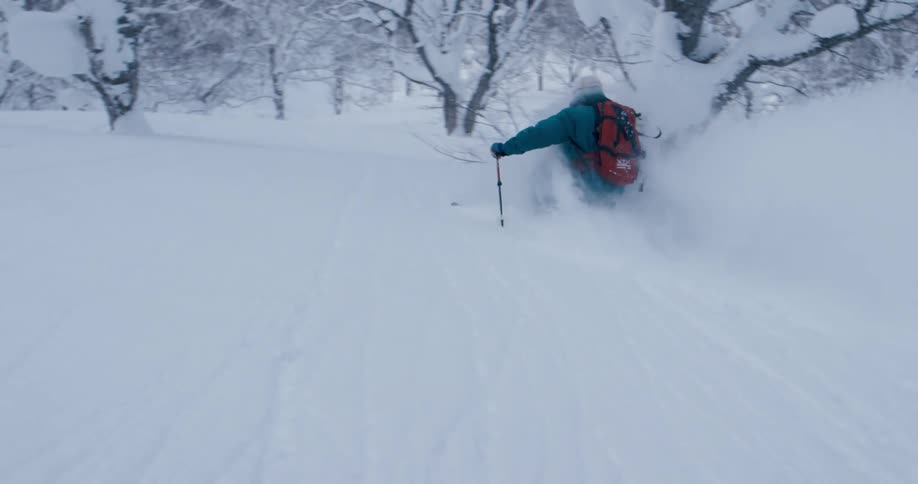 A person is skiing down a hill in winter