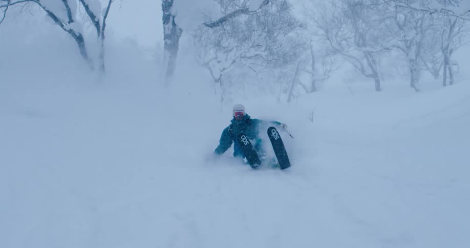 A skier skiing near trees in the snow