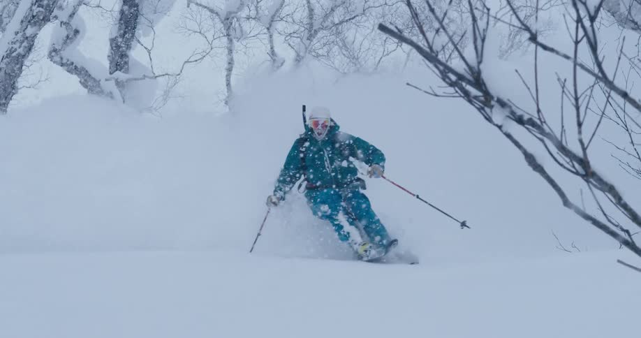 Person downhill skiing in heavy snow