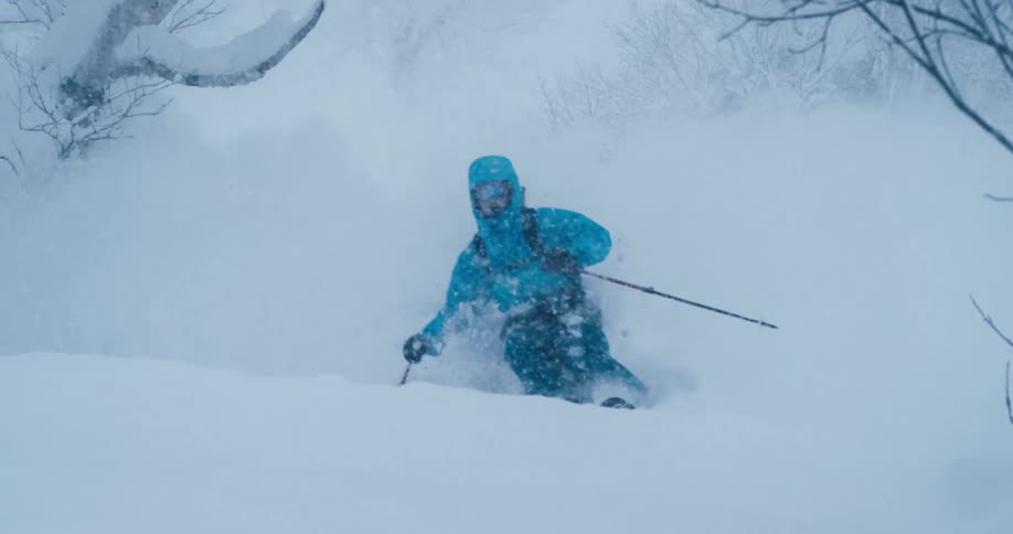 A person a skiing down a snowy mountain