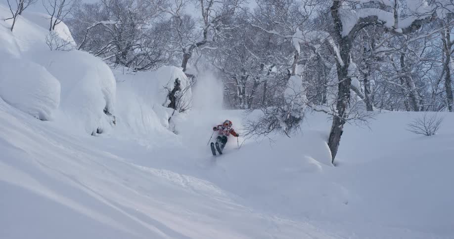 A person is skiing down a hill in winter