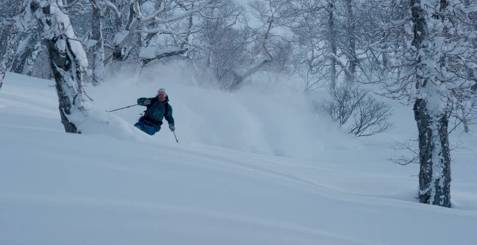 A skier skiing down a snowy mountainside