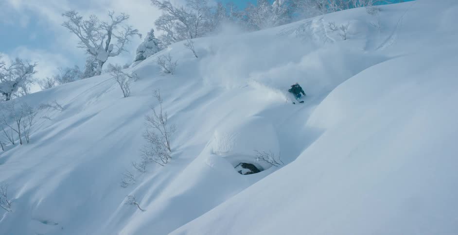 A person is skiing down a hill in winter
