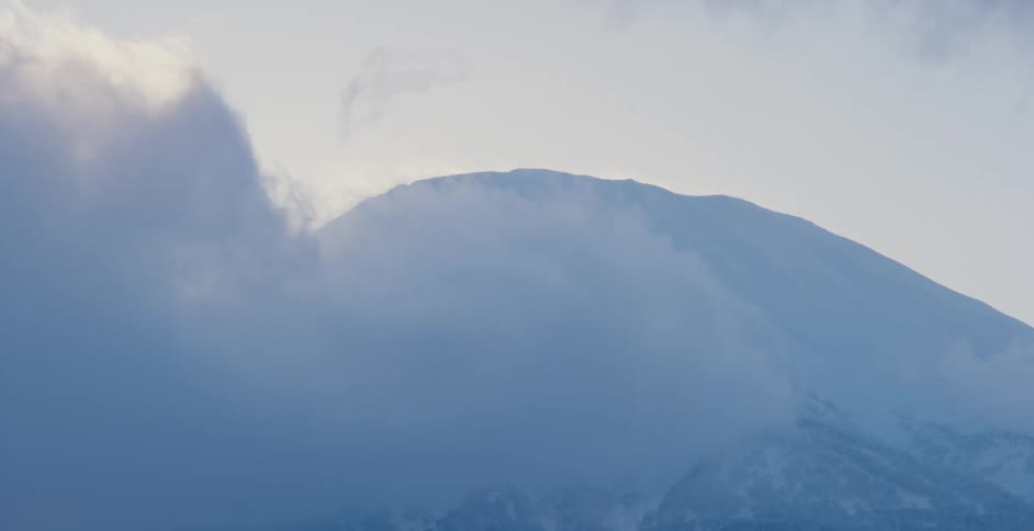 Clouds floating over snowy mountains on a winter day