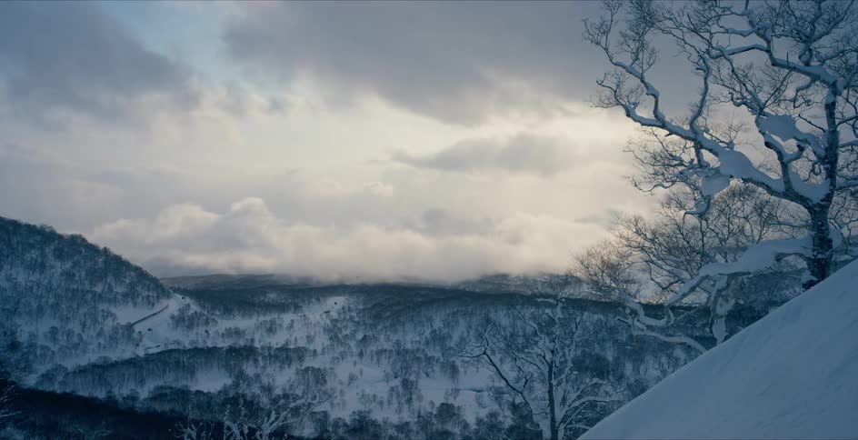 Storm clouds float over snowy hills in nature in winter