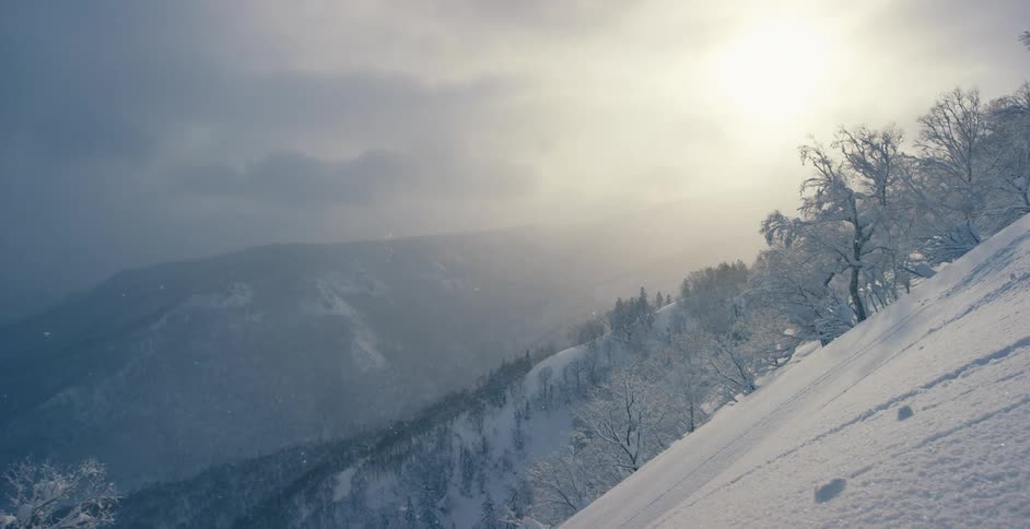 Snow falls in mountains on a chilly winter day