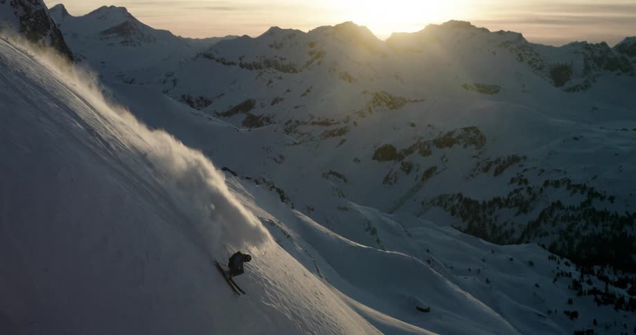 A man is skiing down a mountain in winter