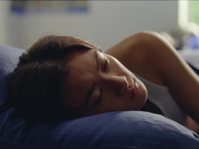 A woman is sleeping indoors during the day