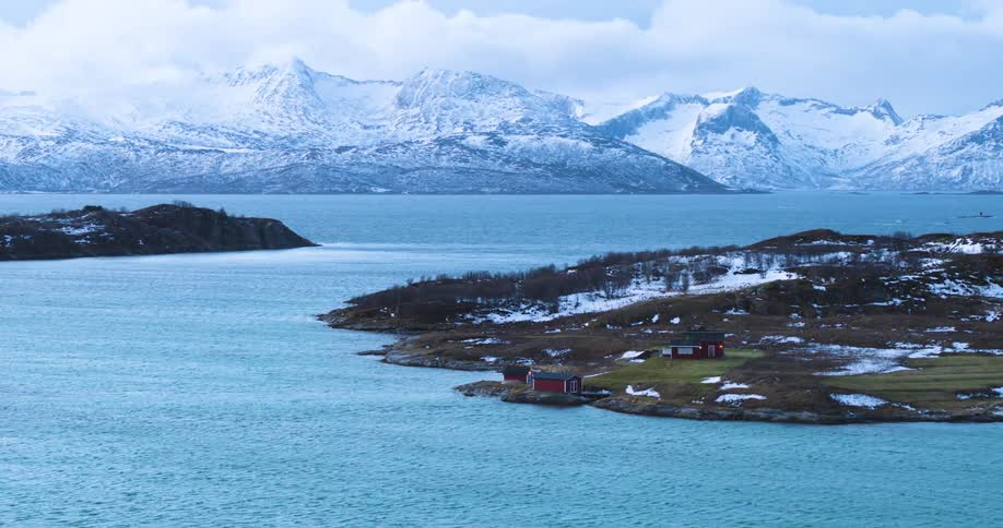 An aerial view of a rural area on the shore by the mountains
