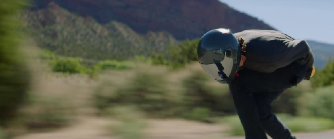 Skateboarder barreling down a road at a high speed