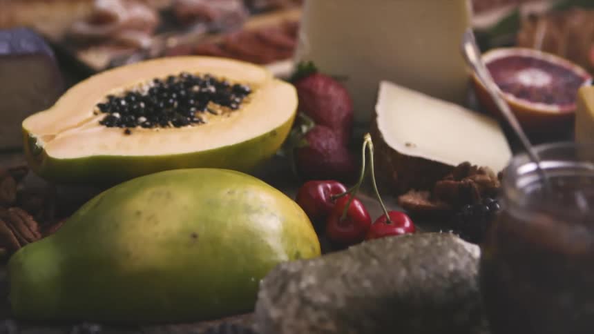 A wooden table covered in meats fruits and vegetables