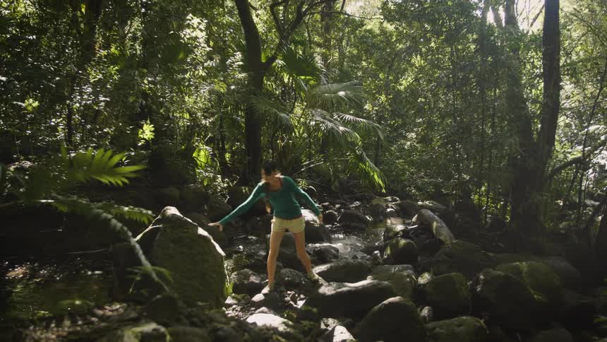 A woman is hiking outdoors in a tropical area