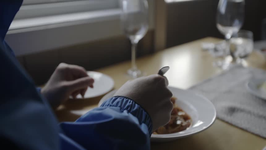 A man chats while eating at a table