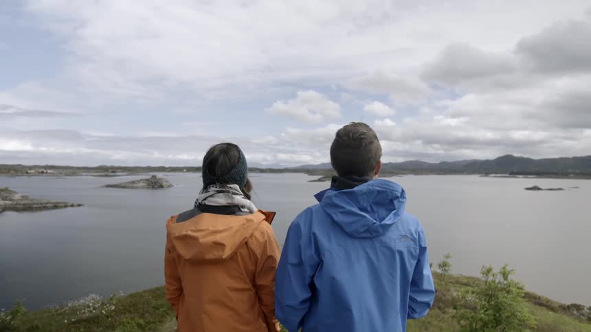 A man and woman look out at a lake