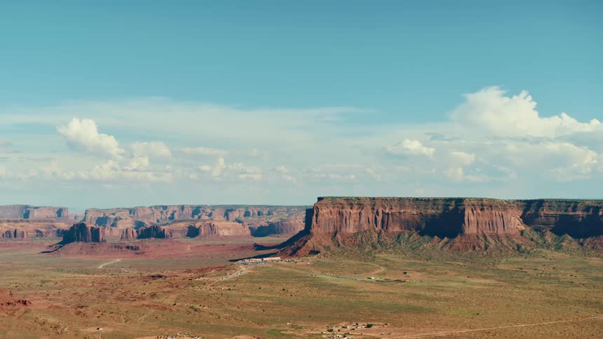 A desert with cliffs and plateaus with the sky and clouds in the background