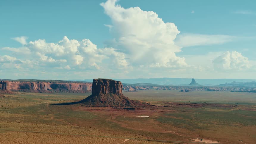 A desert with cliffs and plateaus with the sky and clouds in the background