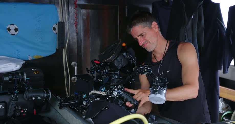 Man examines and works on machine in open cabin