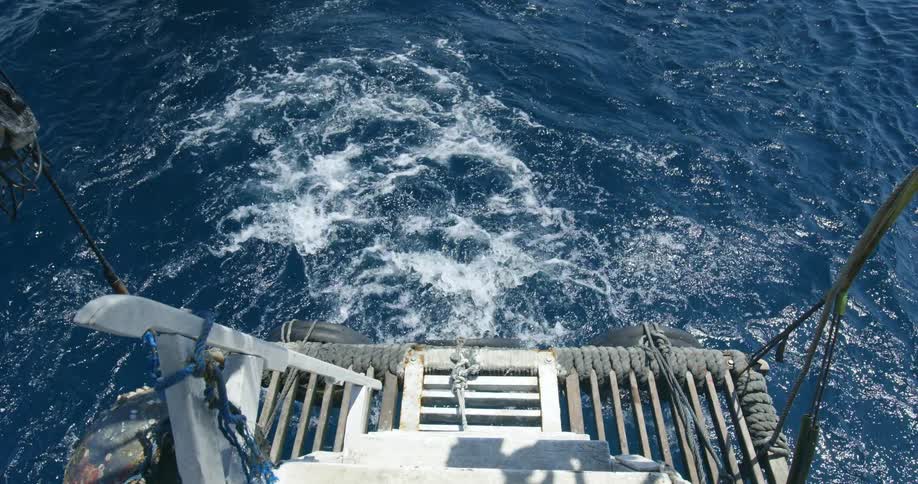 A boat floating on blue ocean water in the daytime