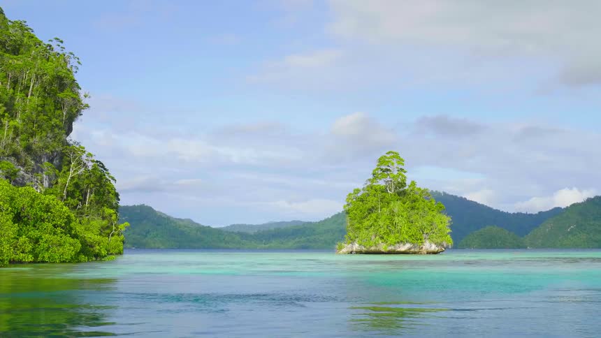 Turquoise ocean water flowing around a tropical island in the daytime