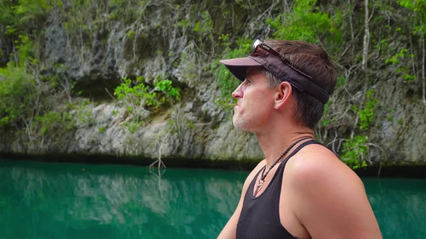 A man relaxing on the water as he talks with someone