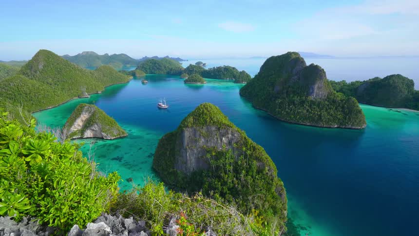An aerial view of boats sailing around islands in the water